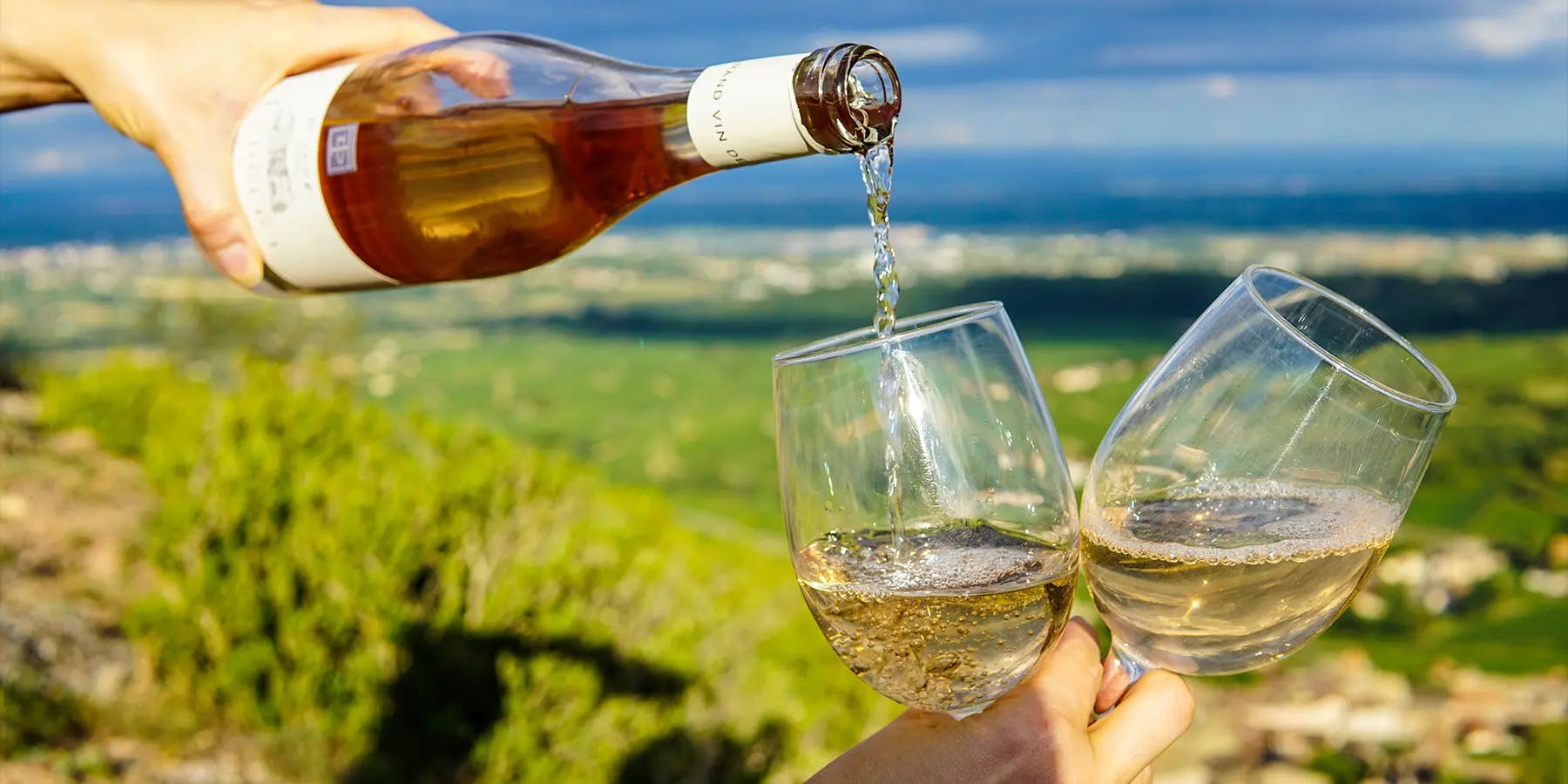 Du vin rosé versé d'une bouteille dans un verre